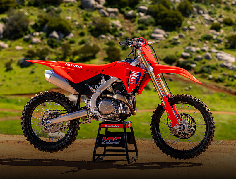 A red dirt bike parked securely on a stand, showcasing its sleek design and off-road capabilities.